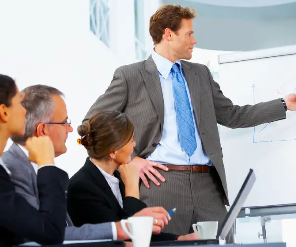 A presenter at a flipchart in front of a team